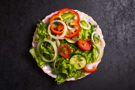chopped vegetables mixed with olive oil, top view, on black backgroundの写真素材