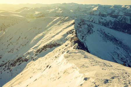 majestic winter landscape of snowy mountains with a clear blue sky in the sunset, the concept of the...