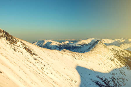 majestic winter landscape of snowy mountains with a clear blue sky in the sunset, the concept of the greatness and beauty of natureの写真素材