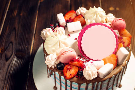 delicious and beautiful dessert cake with strawberries and marshmallows on wooden background and a sign for textの写真素材