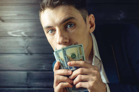 man businessman in a suit with a closed one hundred dollar bills mouth, silent for money. the concept of corruption and briberyの写真素材