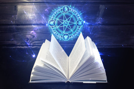 Open magical book with pages like a fan is on the table out comes a colorful light and magic sign....