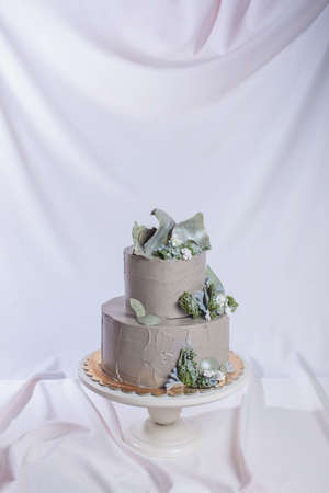 Rustic style wedding cake decorated with stone and the top of the cake with moss and forest flowers. food design. trendsの写真素材