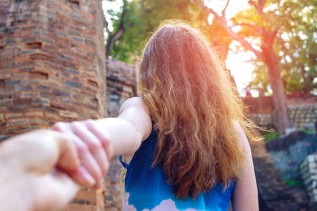 Woman with beautiful hair discovering jungle holding boyfriend's hand. Follow me. Follow me. Travel concept.の写真素材