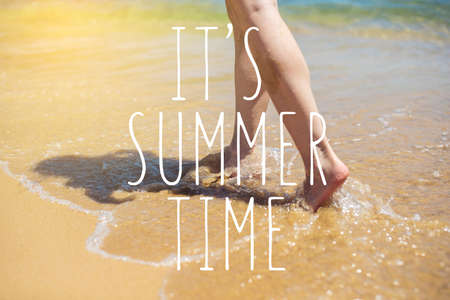 Woman walks barefoot in the sand washed by sea wave on the beach. Summer time, concept of a Paradise vacationの写真素材