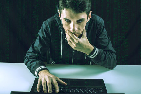 young hacker in the dark breaks the access to steal information and infect computers and systems....