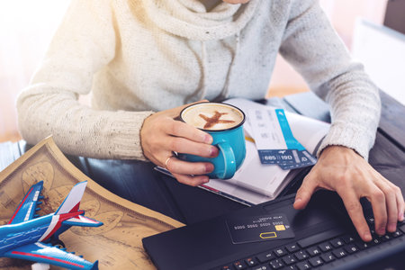 Man holding a credit card and buys plane tickets on the Internet working on the laptop. The concept...