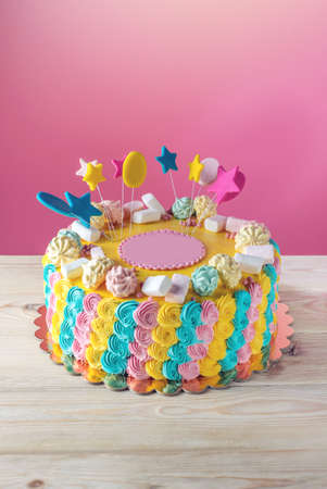 Bright colourful children's cake decorated with marshmallows and meringues for a holiday or birthdayの写真素材