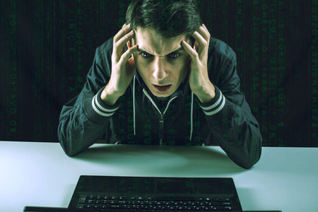 young hacker in the dark breaks the access to steal information and infect computers and systems....