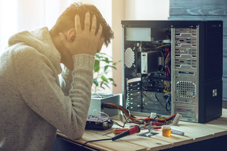 Man repairman broke the computer that was repaired in the service is on a workplace in the office....