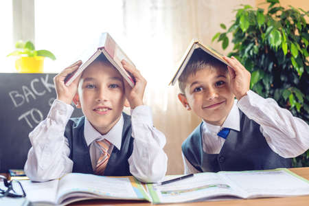 Back to school. Cute children sitting at the desk in the classroom. Boys is learning lessons. Concept for the first time in elementary schoolの写真素材