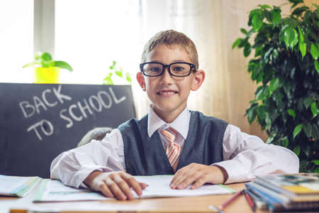 Back to school. Cute child sitting at the desk in the classroom. Concept for the first time in elementary schoolの写真素材