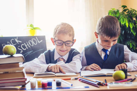 Back to school. Cute children sitting at the desk in the classroom. Boys is learning lessons. Concept for the first time in elementary schoolの写真素材
