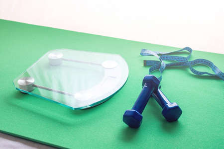 Electronic scales for weight control, dumbbells and measuring tape. The concept of sports training, slimming and weight lossの写真素材