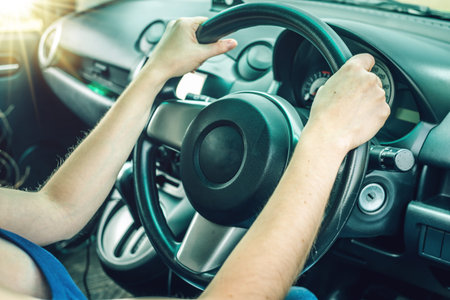 Closeup of female hands on the steering wheel in the car. The concept travel and road mood