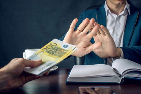 Man businessman in suit refuses to take the money by showing that he is not a grafter. A bribe in the form of Euro banknotes. The concept of corruption and briberyの写真素材