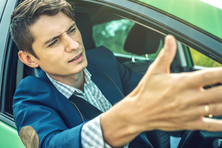 The upset driver man in the car. Quarrels and discontent in the road