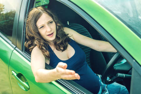 Angry and frustrated woman driver in the car. The quarrel and dissatisfaction on the way.の写真素材