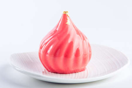 Cake in the form of a dome covered with red glossy glaze with cranberries and honey cake inside on a white background. Concept design pastry dessertsの写真素材