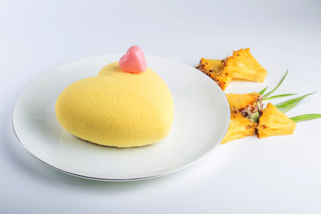 Beautiful yellow cake in the shape of a heart filled with white souffle and pineapple. Concept...