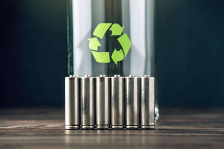 Used AA and proper disposal of toxic to the environment and soil batteries on a blue background. The concept of technologies of processing of harmful and recycling substances for ecologicalの写真素材