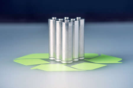 Used AA and proper disposal of toxic to the environment and soil batteries on a blue background. The concept of technologies of processing of harmful and recycling substances for ecologicalの写真素材
