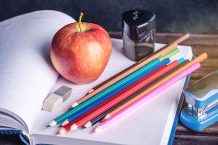 School supplies are on the table. Books, pencils and apples is a collection of the student. The concept of school and educationの写真素材