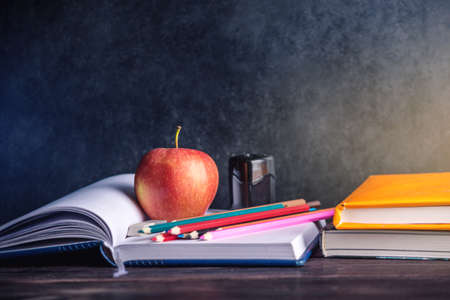 School supplies are on the table. Books, pencils and apples is a collection of the student. The concept of school and educationの写真素材