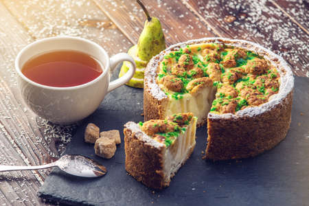 Homemade Christmas or New Year holiday pear pie decorated in a rustic style on wooden table background. The concept of festive dessertsの写真素材