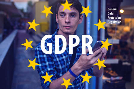 General Data Protection Regulation GDPR . The text with the EU flag in the background a man uses a mobile phoneの写真素材