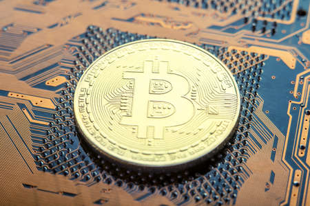 Coin Bitcoin on the electronic Board. Mining cryptocurrency. The concept of technologies blockchain of virtual currenciesの写真素材