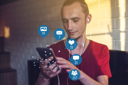A young man uses the phone for entertainment and communication on the Internet and viewing...