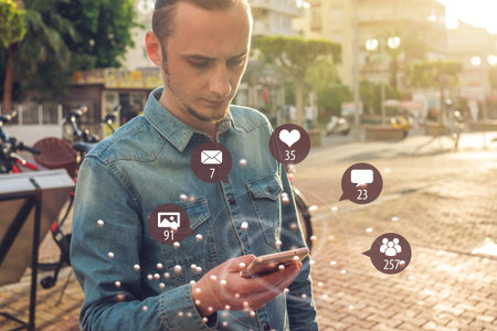 A young man uses the phone for entertainment and communication on the Internet and viewing...