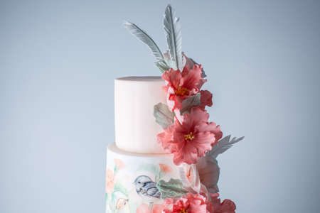 Beautiful home wedding four-tiered cake decorated with spring red flowers and handmade pattern. The concept of delicious dessertsの写真素材