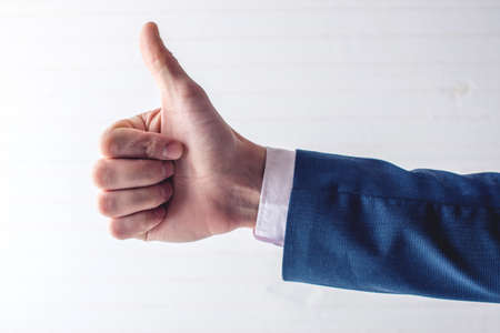 Like this. Close-up of human hand with thumb up in front of the blackboardの写真素材