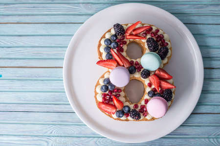 Homemade cake in the shape of a digit 8 decorated with white cream and strawberries blueberry and BlackBerry. Sweet dessert as a gift for women's day on Marchの写真素材
