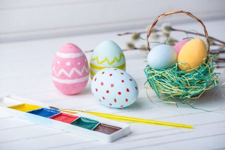 Colorful bright Easter eggs with paints hand painted on a white wooden background. Festive spring cardの写真素材