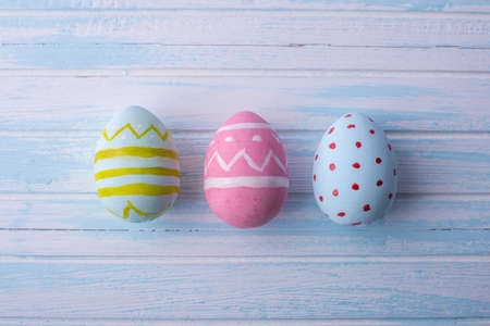 Colorful bright Easter eggs hand painted on a blue background. Holiday spring cardの写真素材