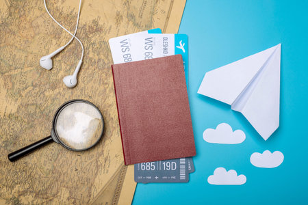 Air tickets with passport and paper plane on world map background, topview. Bright Pastel...