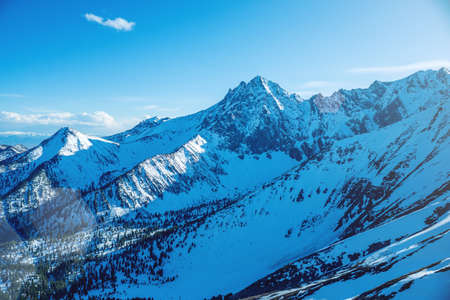 Landscape of snow-capped peaks of the rocky mountains in Sunny weather. The concept of nature and travelの写真素材