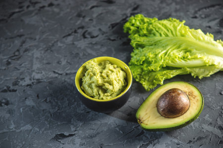 Traditional Mexican cold appetizer made of pureed avocado pulp with bread and vegetables on the...