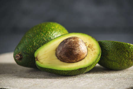 Avocado fruit cut in half on the linen fabric background. The concept organic eco products for food and cosmetic proceduresの写真素材