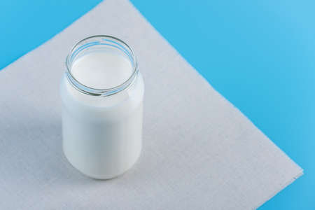Glass bottle with fresh milk on blue background.の写真素材