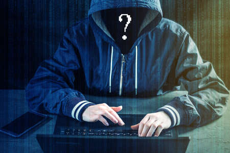 Anonymous hacker programmer uses a laptop to hack the system. Stealing personal data.の写真素材