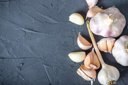 Group of garlic cloves scattered on a table on a white background. An important ingredient in different cuisines of the world. A healthy product.の写真素材