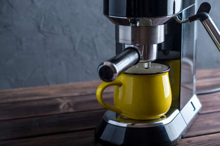 Preparation of espresso. Black coffee machine on the table. Professional coffee brewing at homeの写真素材