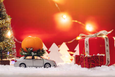 Toy car carries gifts in the Christmas and new year's eve on a blue background. The concept of holiday shopping and discountsの写真素材