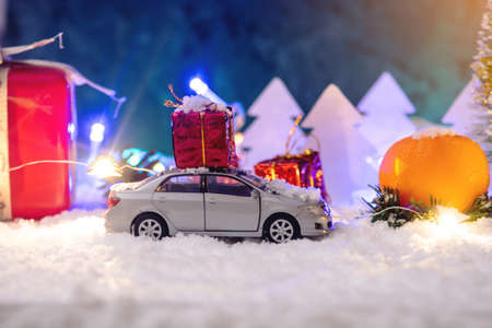 Toy car carries gifts in the Christmas and new year's eve on a blue background. The concept of holiday shopping and discountsの写真素材