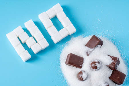 Text No is lined with sugar cubes with sweets candy. The concept of harm to the health of sweet and rejection of sucroseの写真素材