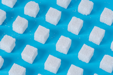 Pattern of sugar refined cubes with shadows on a blue background. The concept of harmful ingredient for confectioneryの写真素材